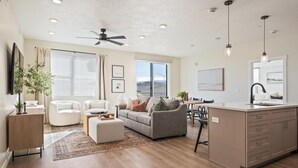 A spacious living area with a sofa, ottoman, and a dining table. - Drop It Like It's Hot 2 Bedroom Condo (St. George)