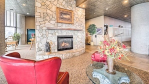 A lobby with a stone fireplace, red leather chairs, and a vase of flowers. - 3 Mi to Sugar Mtn Slopes! Condo w/ Hot Tub & Pool (Banner Elk)