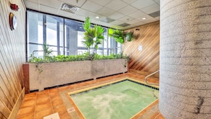 A spa area with a hot tub, tiled flooring, and a concrete planter with plants. - 3 Mi to Sugar Mtn Slopes! Condo w/ Hot Tub & Pool (Banner Elk)