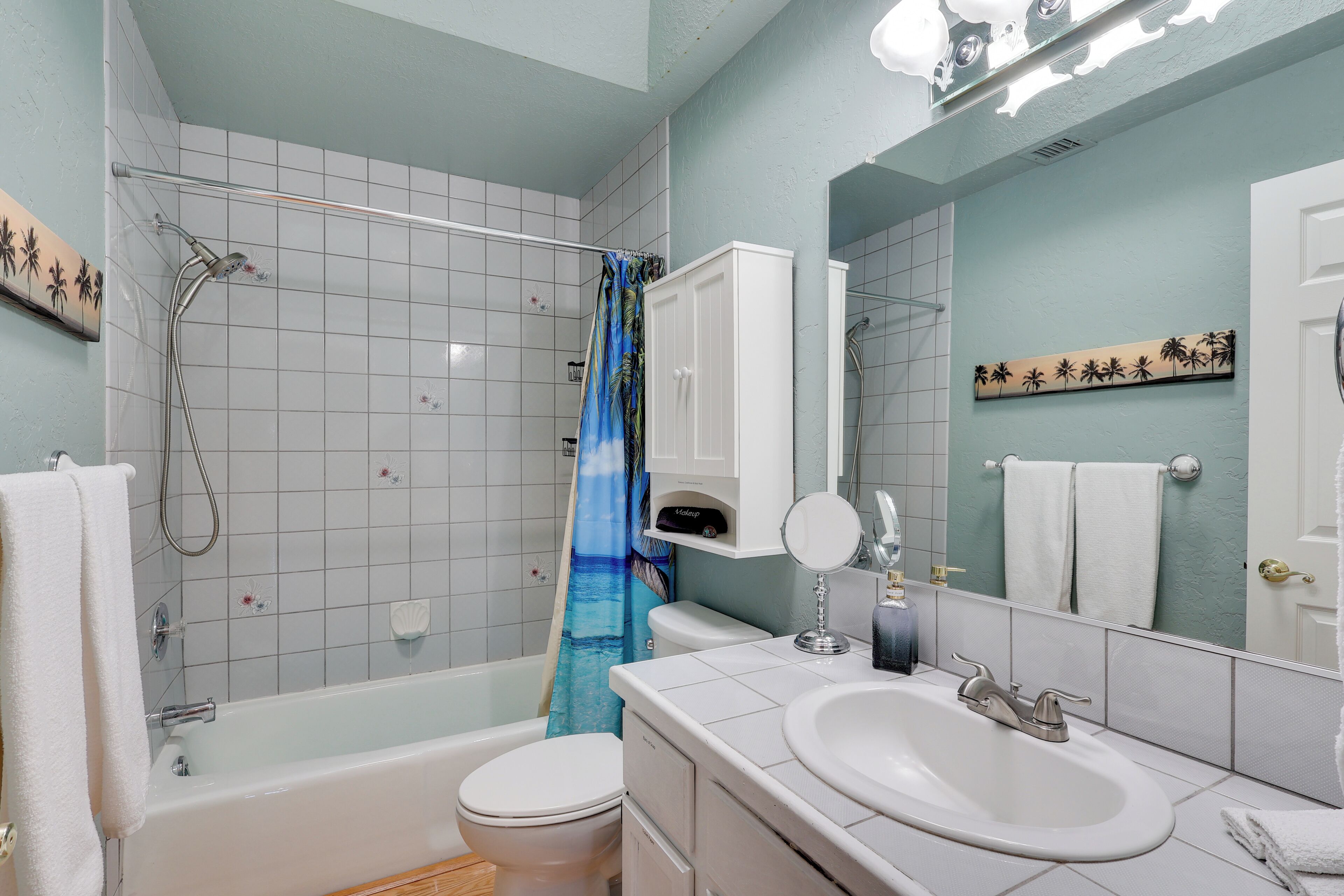 A bathroom with a bathtub, toilet, sink, and a shower with a curtain.