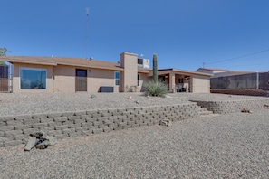 A house with a sloped roof, a large window, and a cactus in the front yard.