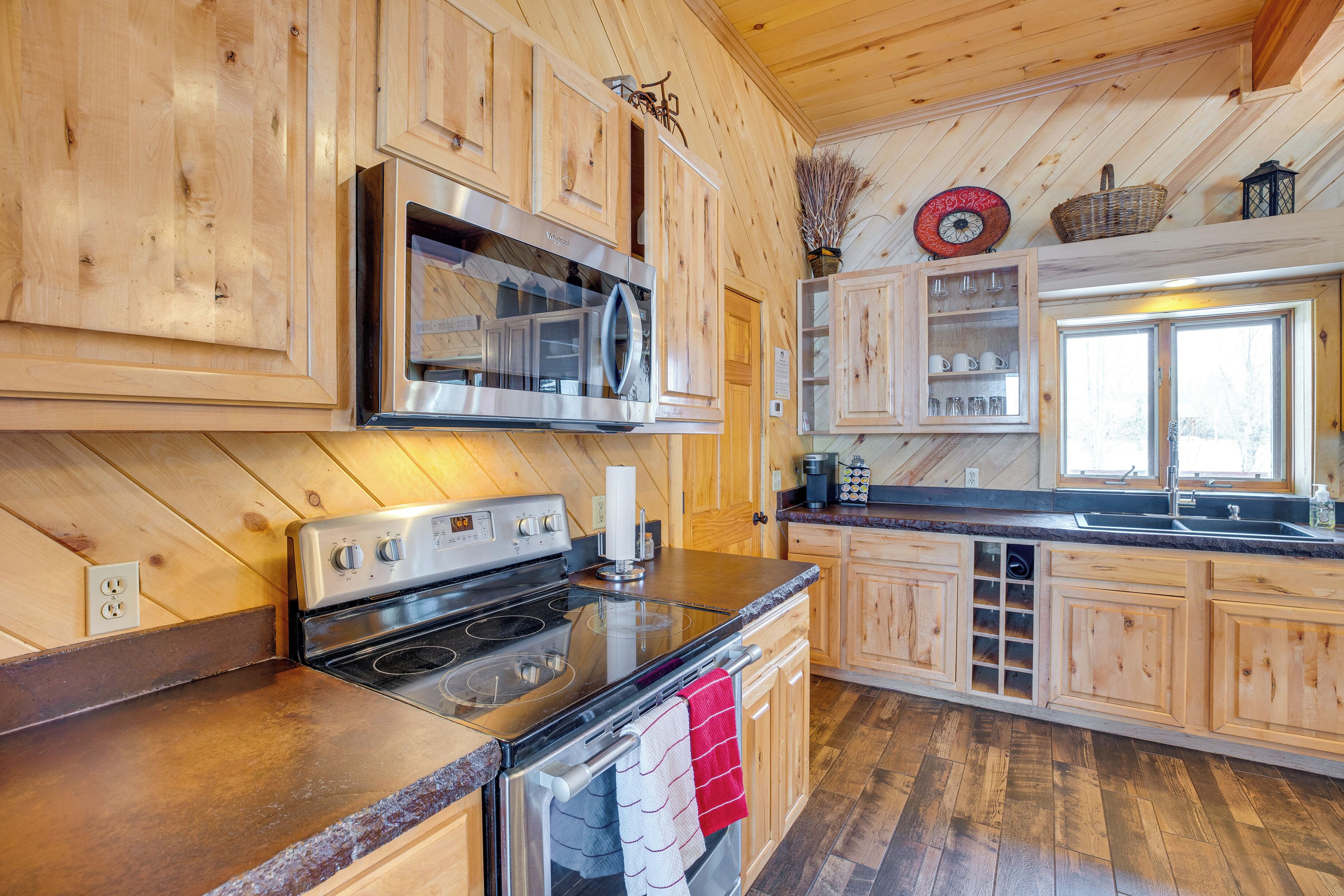 A kitchen with wooden cabinets, stainless steel appliances, and a large window.