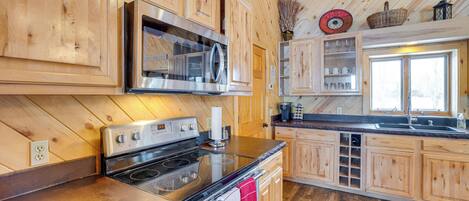 A kitchen with wooden cabinets, stainless steel appliances, and a large window.
