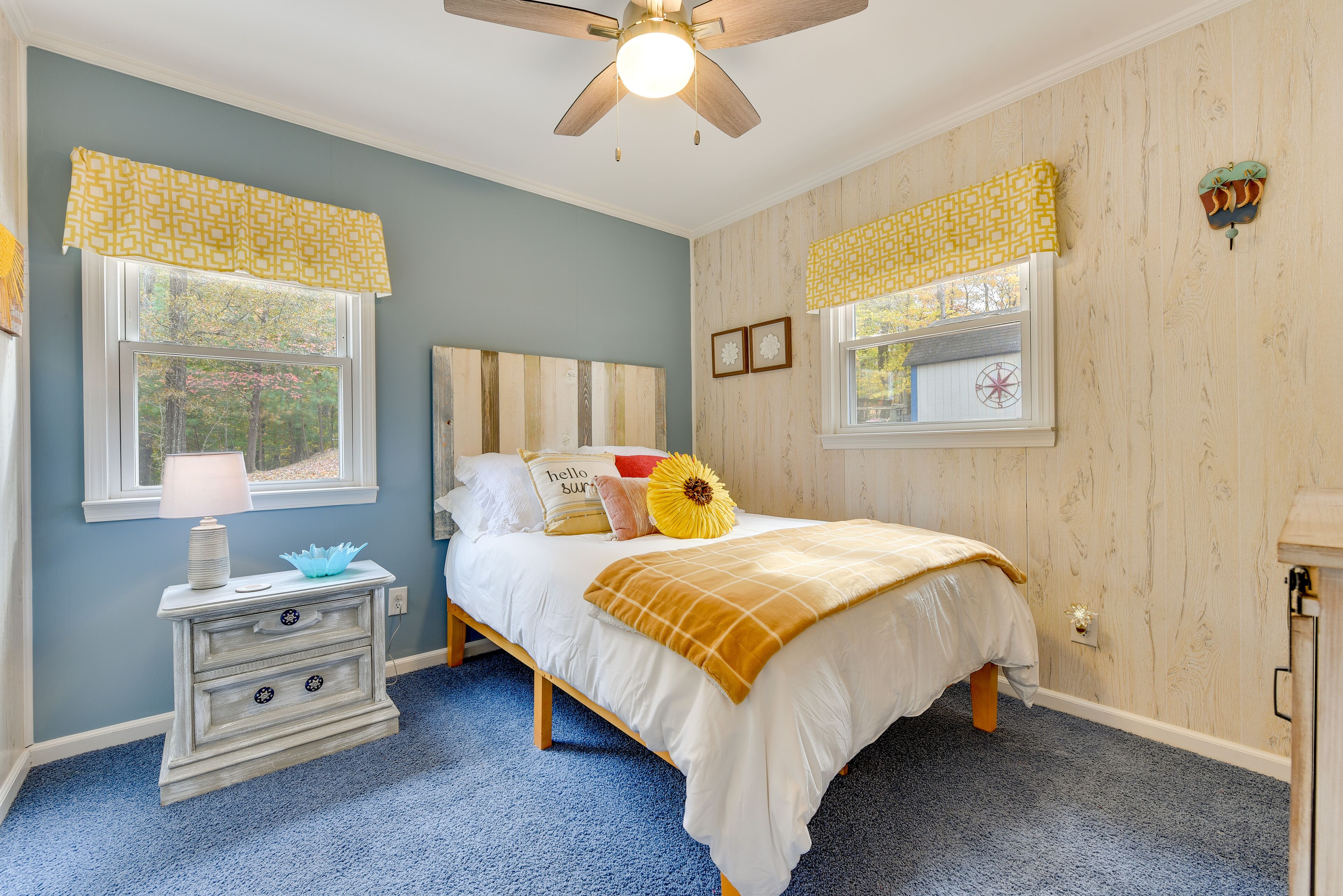A bedroom with a bed, nightstand, and window with curtains.