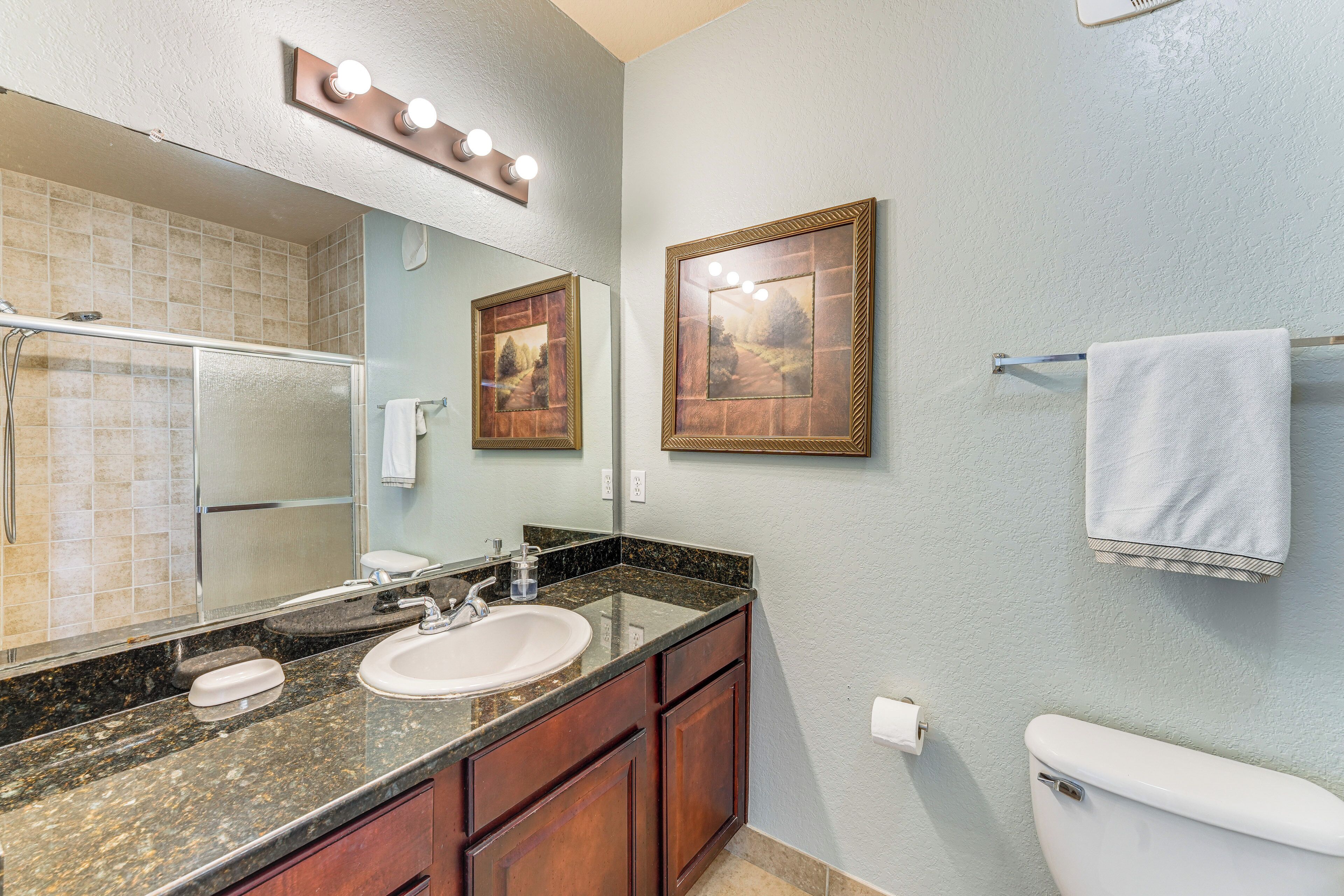 A bathroom with a sink, mirror, and toilet.
