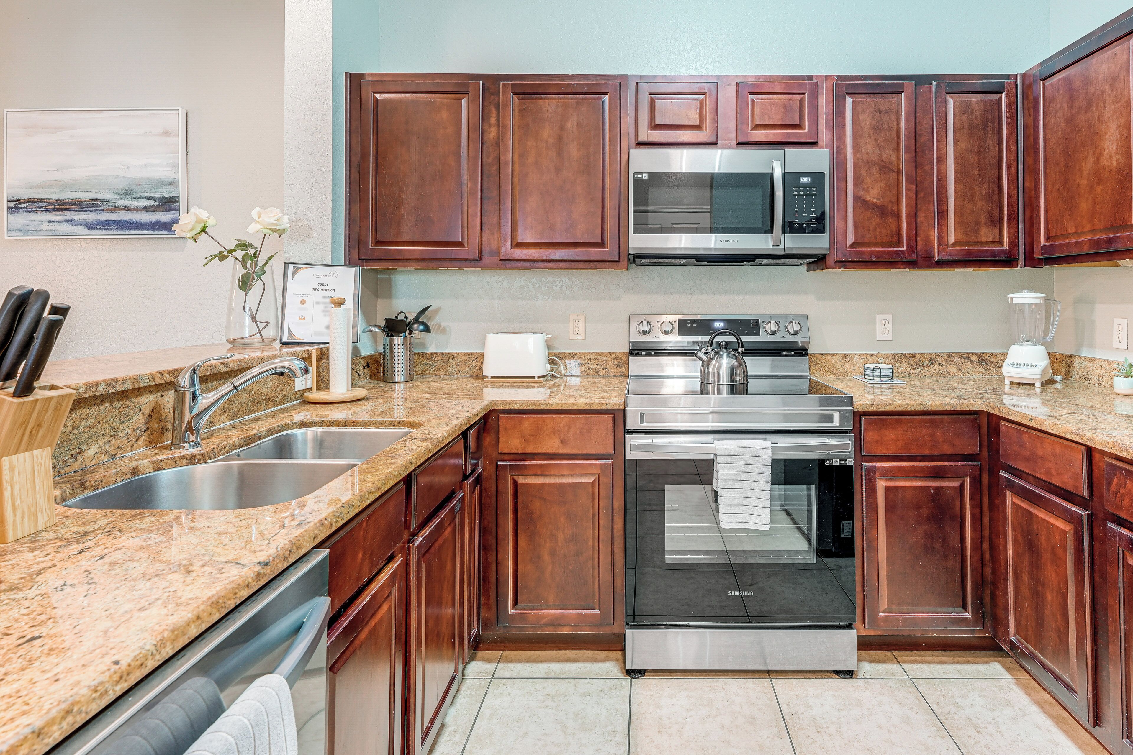 A modern kitchen with granite countertops, stainless steel appliances, and wooden cabinets.