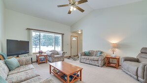 A spacious living room with a ceiling fan, two sofas, a coffee table, and a TV. - Cozy Mancelona Home: Ski, Golf & Snowmobile! (Mancelona)