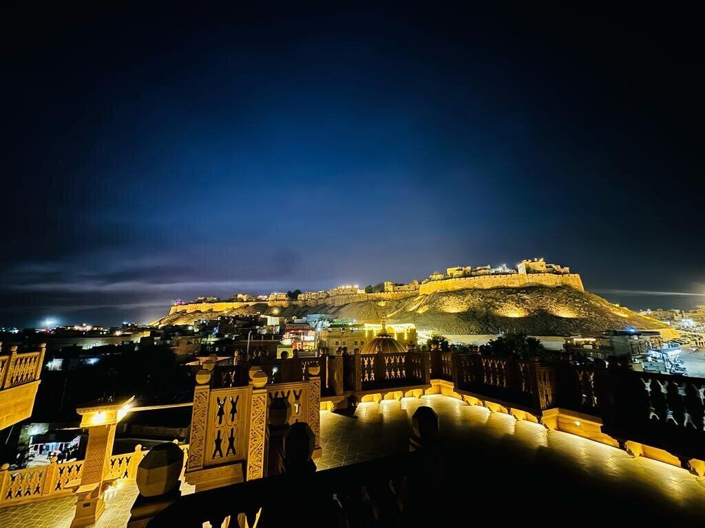 Eine historische Festung mit Blick auf eine Stadt bei Nacht.