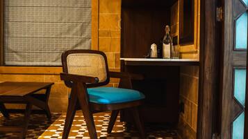 A corner room with a wooden chair, a small table, and a tiled floor.