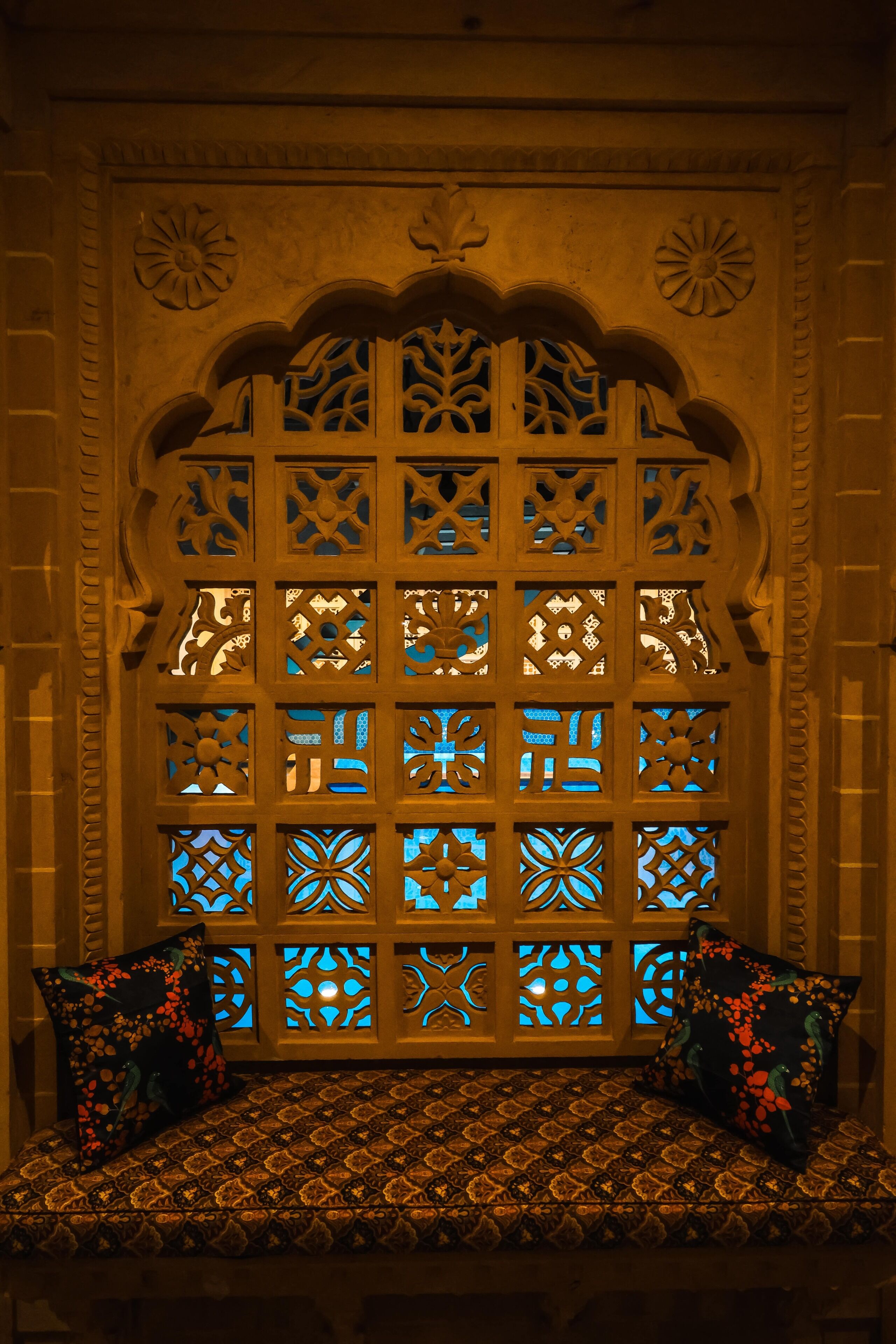 A room with a patterned bench and a decorative wall with intricate designs.
