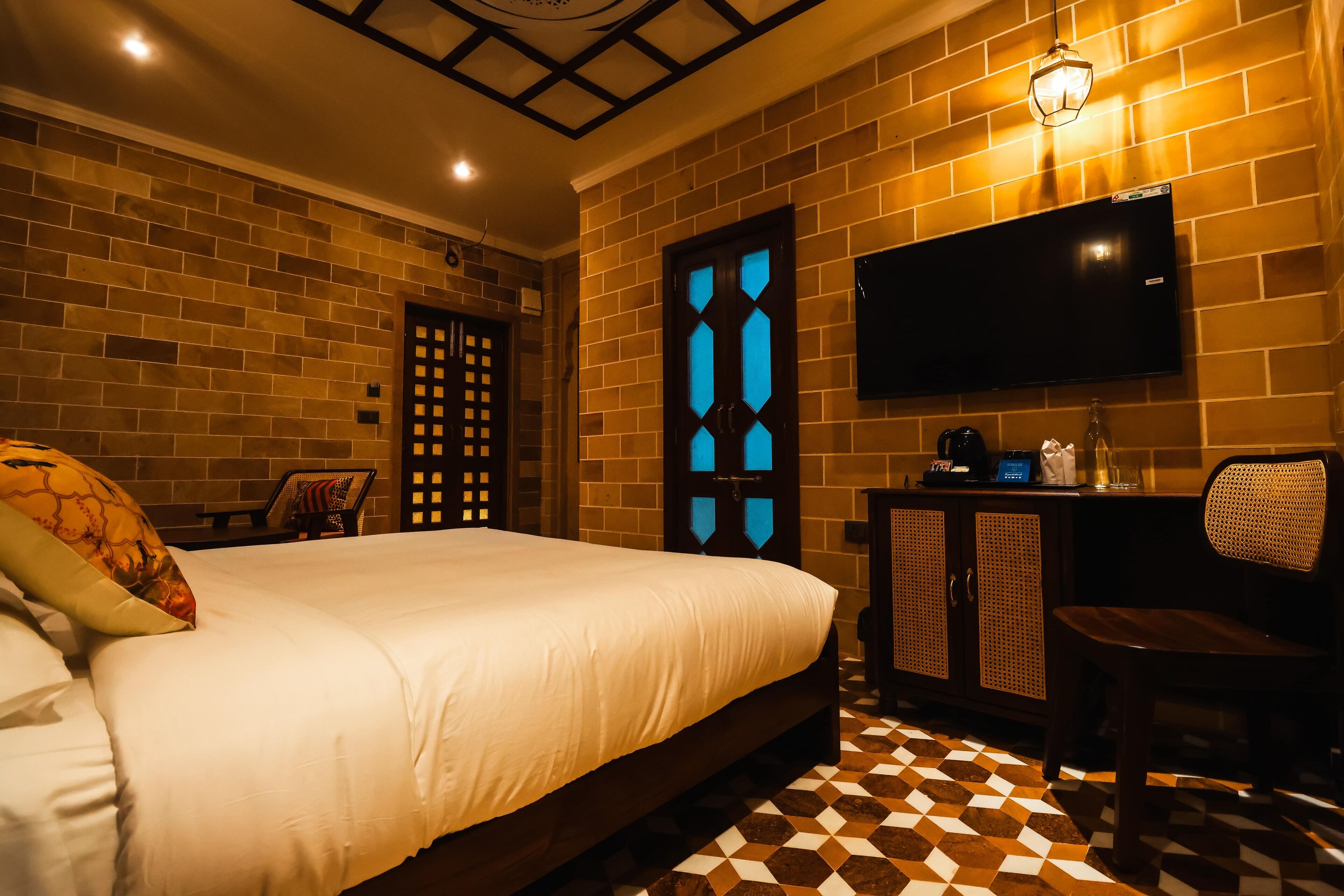 Une chambre d’hôtel avec un grand lit, un téléviseur fixé au mur, une armoire en bois et un comptoir d’enregistrement.