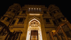 A grand building with a large arched entrance and multiple windows.