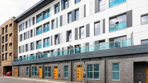 A multi-story building with a modern architectural design, featuring a mix of brick and glass facades, and a flat roof.