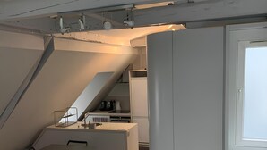 A modern loft apartment with a dining area, kitchen, and a large window. - Spacious Stunning 6th Floor Apartment in Renovated "Haussmannian" Building (Paris)