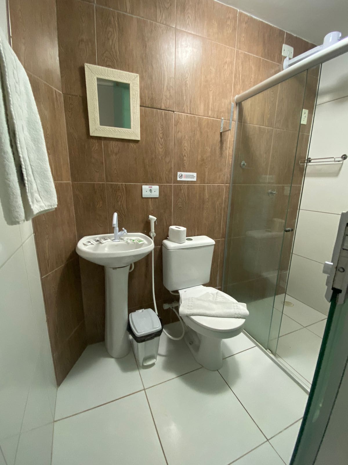 A bathroom with a sink, toilet, and glass shower enclosure.