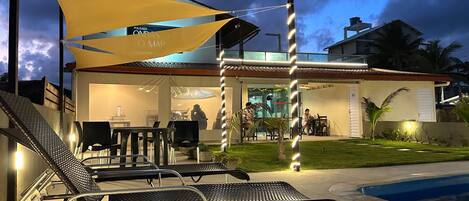 A modern outdoor seating area with metal chairs and a pool.