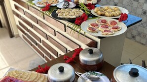 A buffet table with various food items and condiments. - Pousada Ondas do Mar (Ipojuca)