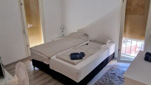 A bedroom with a bed, a fan, and a small rug. - Apartment Budin 2 Rijeka City Center (Rijeka)