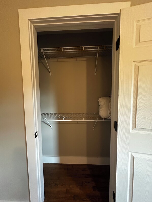 A walk-in closet with a metal shelving unit and a hanging rod. - 5 min walk to warehouse district! Hot tub!!! (Cullman)