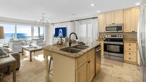 A spacious kitchen with granite countertops, stainless steel appliances, and a view to the outside.
