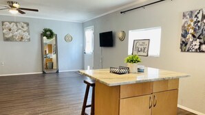 A spacious kitchen with a central island, wooden cabinets, and a ceiling fan. - Farm living by Santos Trails & the Villages! (Summerfield)