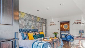 Ein modernes Schlafzimmer mit einem großen Bett, einem Schreibtisch und einem durchgegangenen Tür zugehörigen Badezimmer.