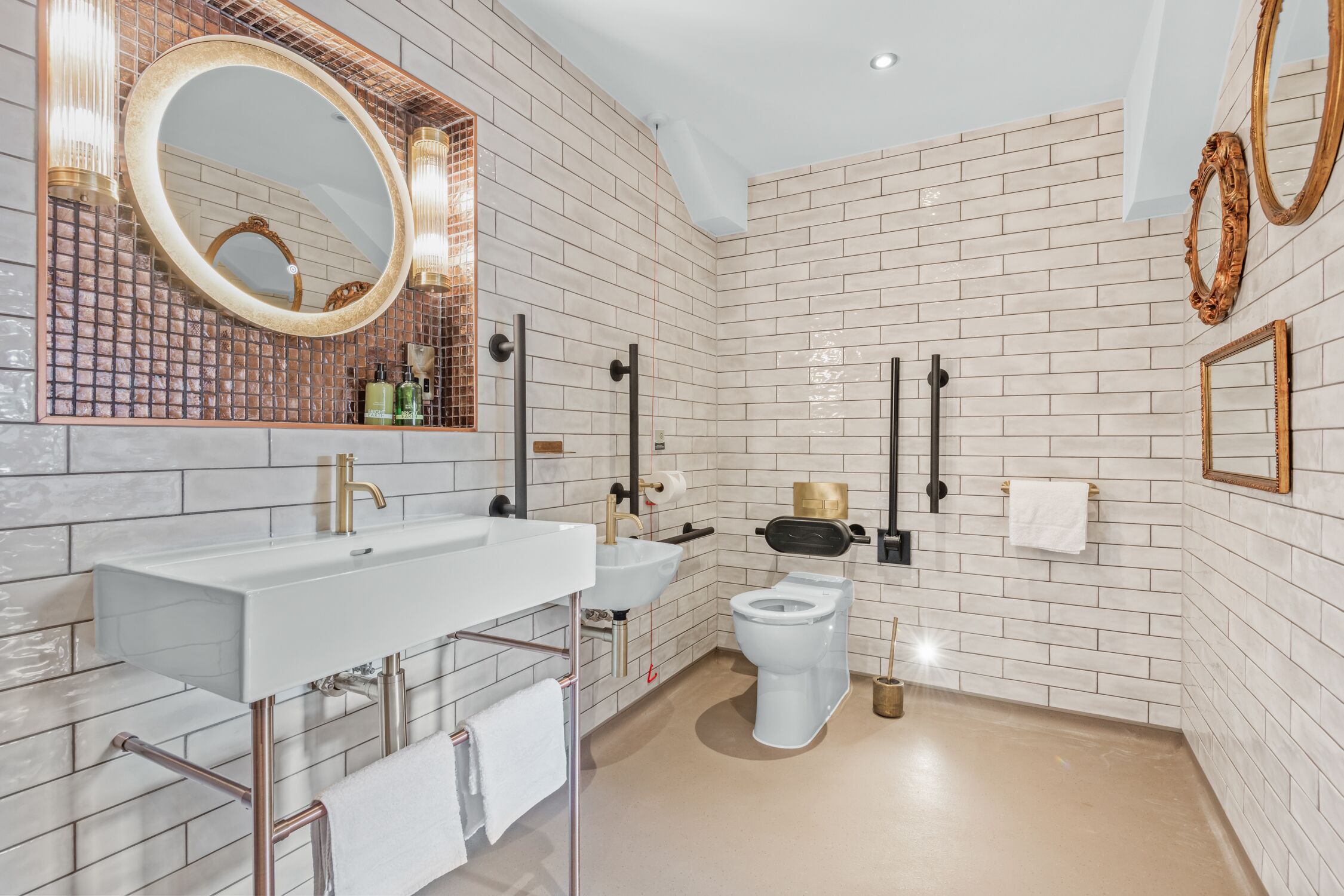 A modern bathroom with a white sink, mirror, and toilet.