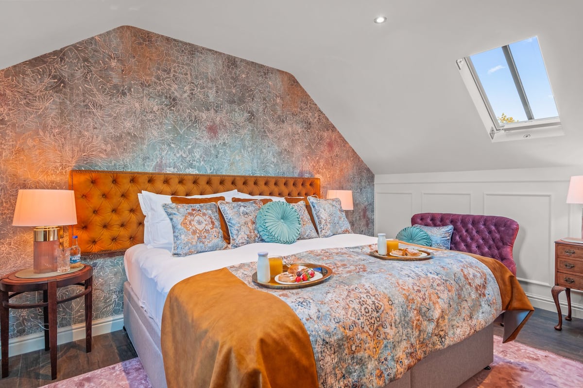 Quarto com uma cama grande, uma janela e uma decoração na parede.