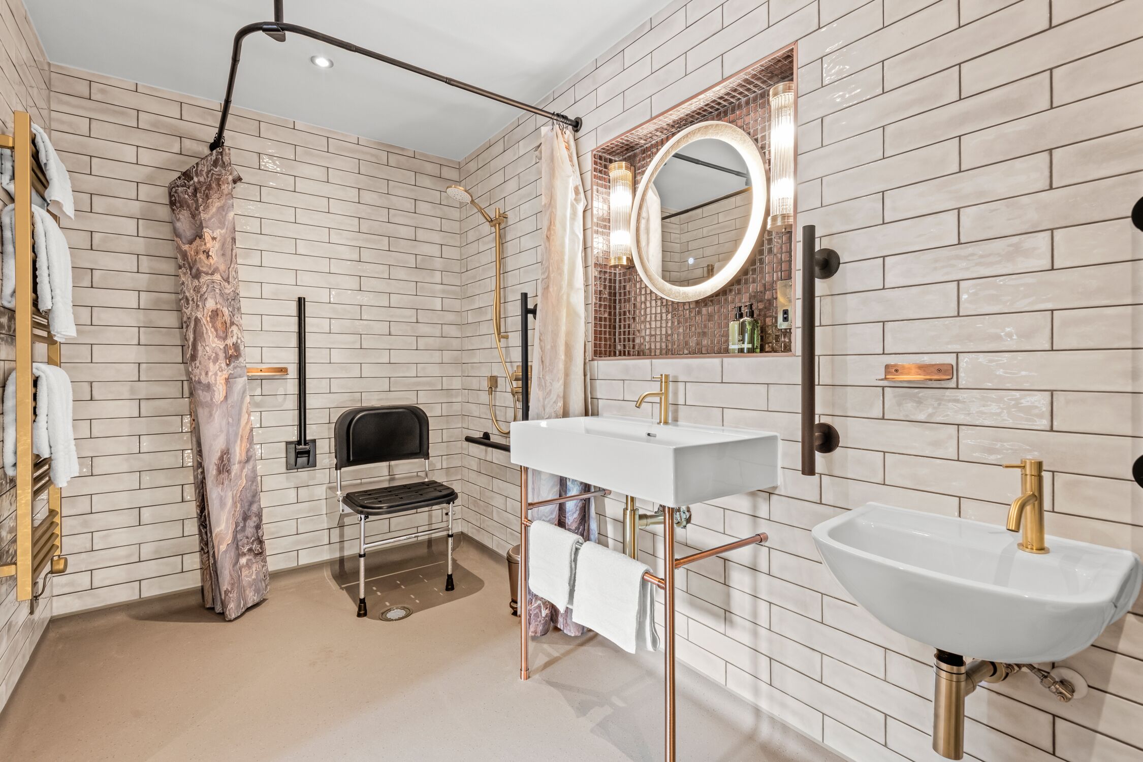 A modern bathroom with a white sink, a large mirror, and a shower area.