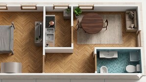 Eine Zweizimmerwohnung mit Küchenzeile, Essbereich, Sofa und Badezimmer.