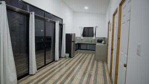 A modern kitchen with a large island, sliding glass doors, and a tiled floor. - Apartment Pinilla With 2 Room, Kitch, a/c (Pinilla)