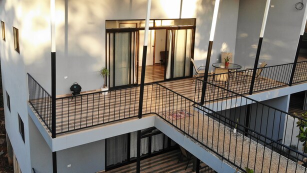 A multi-level residential building with a balcony, a staircase, and a sliding glass door leading to an interior space. - Apartment Pinilla With 2 Room, Kitch, a/c (Pinilla)
