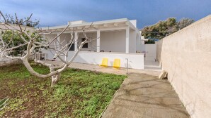 A modern building with a covered outdoor area, a concrete pathway, and a small garden. - 3700 La Spiaggetta - Bilo Lato by Barbarhouse (Porto Cesareo)