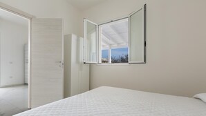 A bedroom with a bed, a wardrobe, and a window with a view of the outside. - 3700 La Spiaggetta - Bilo Lato by Barbarhouse (Porto Cesareo)