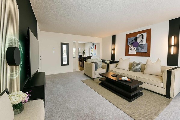 A modern living room with a sofa, coffee table, and artwork.