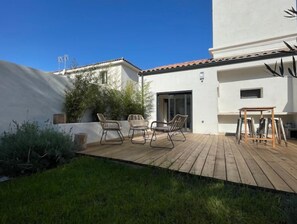 Relax on the patio with wicker chairs and a wooden table, steps from your entrance.