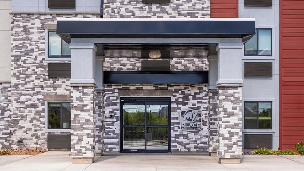 A modern building with a stone facade, a black entrance, and a logo that reads "my PLACE". - My Place Hotel-Tucson North/Marana/Cortaro, AZ (Tucson)