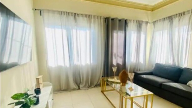 A living room with a sofa, a coffee table, and curtains.