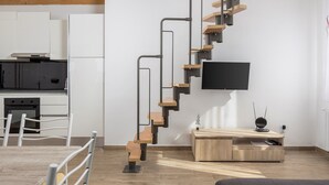 Una cucina moderna con mobili bianchi, un piano cottura nero e un tavolo da pranzo in legno con sedie.