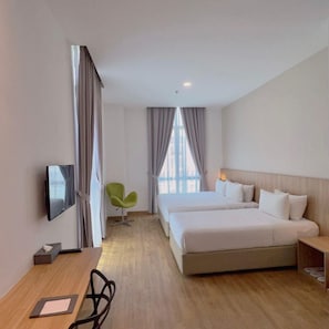 A hotel room with a bed, a desk, a chair, a television, and a window with curtains. - S Hotel (Johor Bahru)