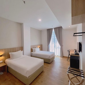 A hotel room with two beds, a desk, a chair, and a television. - S Hotel (Johor Bahru)