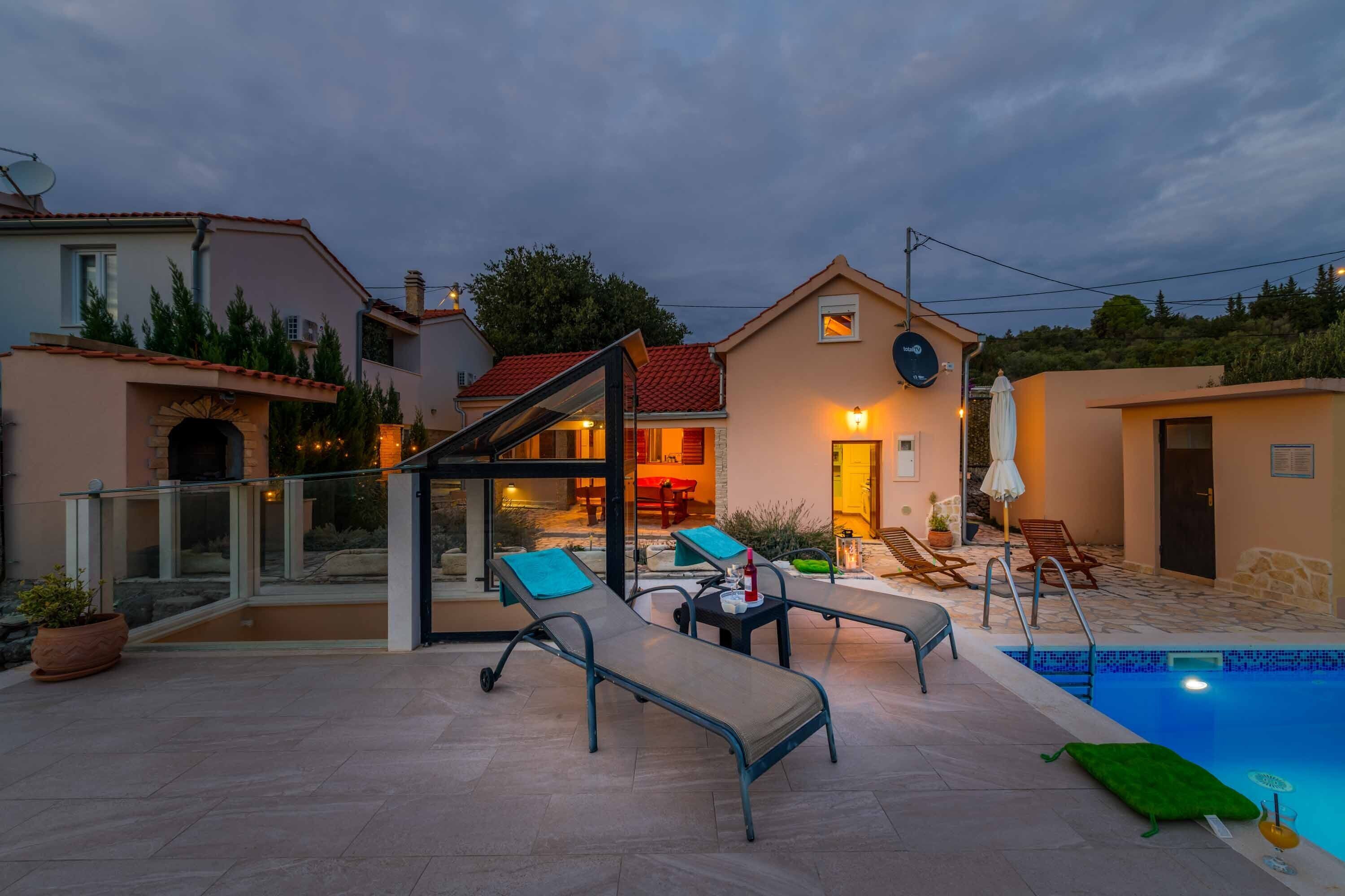 A poolside area with lounge chairs, a glass-enclosed patio, and a swimming pool.