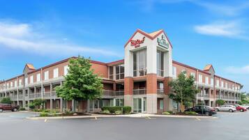 A RealRoof Inn with a brick facade, multiple balconies, and a parking lot.