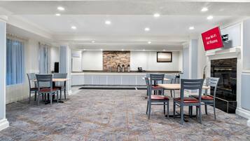 A spacious dining area with a stone backsplash, a fireplace, and a sign indicating free Wi-Fi in all rooms.