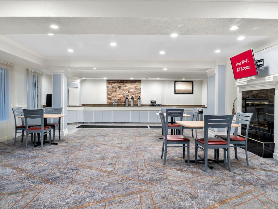 A spacious dining area with a stone backsplash, a fireplace, and a sign indicating free Wi-Fi in all rooms.