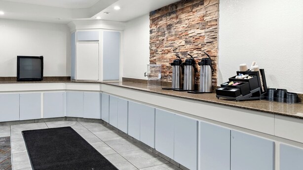 Una cocina moderna con una pared de acento de piedra, armarios empotrados y una estación de café.