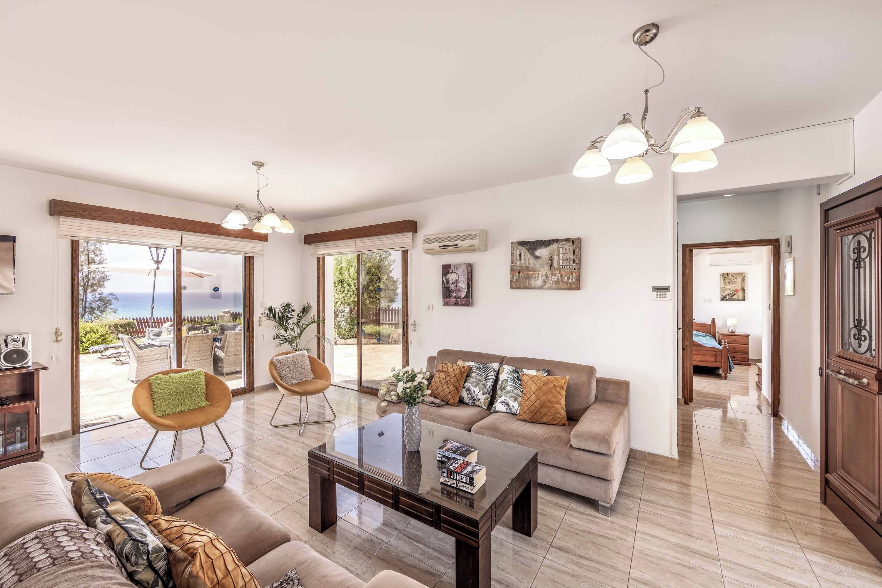 Un salon spacieux avec un canapé, une table basse et des fauteuils, un balcon avec vue et un coin repas comprenant une table et des chaises.