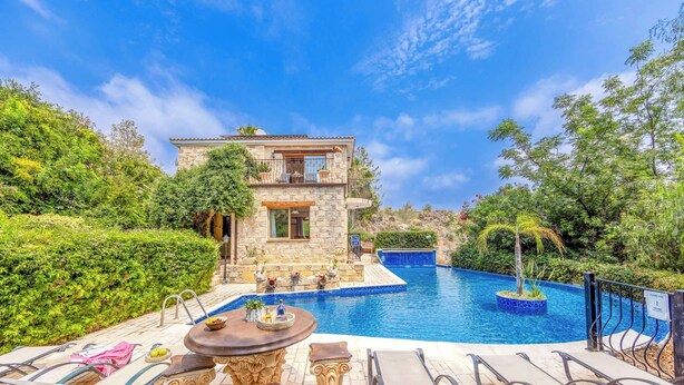 A stone house with a pool, surrounded by greenery. - Villa Sweet Memories (Argaka)