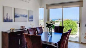 A dining area with a table, chairs, and a view of the outdoors. - Sea Breeze Hideaway - Three Bedroom Villa, Sleeps 6 (Latchi)