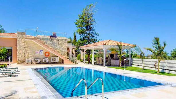 A swimming pool with a stone wall and a covered seating area. - Sea Breeze Hideaway - Three Bedroom Villa, Sleeps 6 (Latchi)
